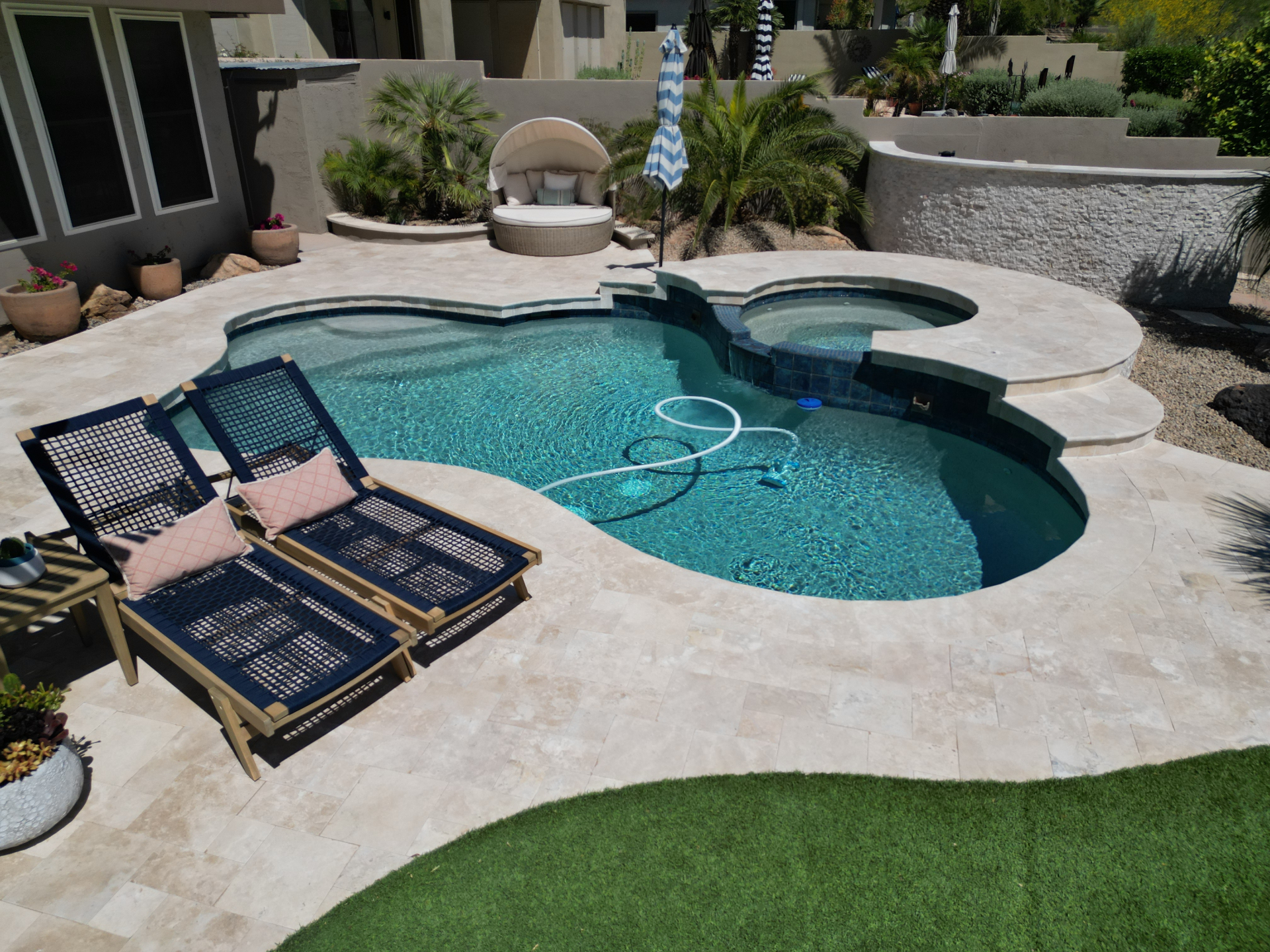 Travertine pool and spa surround with French pattern deck